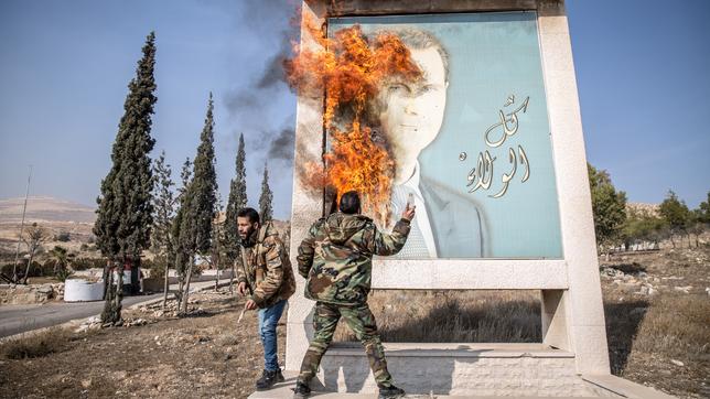 Ein Mann verbrennt ein Bild des ehemaligen syrischen Präsidenten Bashar al-Assad in der Nähe der syrischen Grenze zum Libanon. 