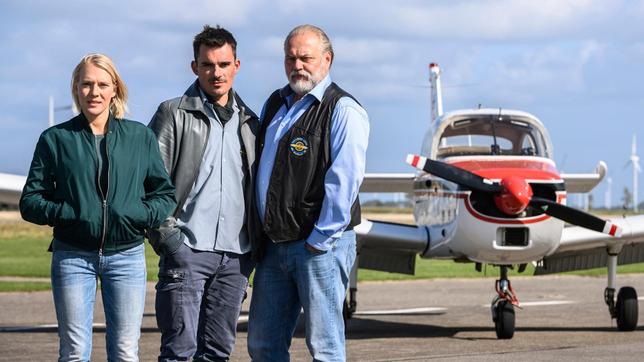 Ohne Swantje (Nadine Boske) geht auf dem beschaulichen Flugplatz ihres Vaters Hauke (Jan-Gregor Kremp, re.) in Büsum nichts. Swantje repariert die in die Jahre gekommenen Maschinen und organisiert den Post- und Passagierbetrieb. Nur selbst zu fliegen, traut sich die passionierte Pilotin nicht mehr. Das ist für den Flugbetrieb ein existenzielles Problem, denn Hauke soll aufgrund des Grauen Stars die Fliegerei sein lassen. Wie ein Geschenk des Himmels erscheint es da, als Haukes „verlorener Sohn Sönke (Hannes Wegener) überraschend mit seinem schnittigen Flieger namens „Suse“ einschwebt.