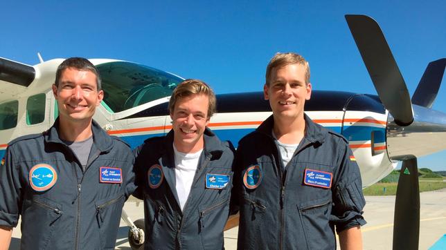 Checker Tobi (Mitte) mit Marc Puskeiler und Thomas van Marwick vor einem Klima-Forschungsflugzeug des Deutschen Zentrums für Luft- und Raumfahrt in Oberpfaffenhofen. 