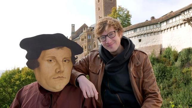 Robert und eine Person in Martin Luther-Kostüm mit Laternen in einem Wehrgang der Wartburg in Eisenach.
