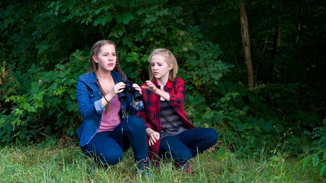 Uferböschung am See: Greta (Enya Elstner) und Nele (Jule-Marleen Schuck) entdecken Roy Freitag auf dem See.