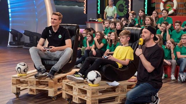 FIFA-Profi Benedikt Saltzer zeigt was er an der Konsole kann. Da haben die Schulkinder und Moderator Johannes keine Chance.