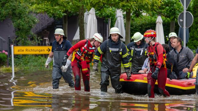 Hochwasser in Bayern: Mit einem Schlauchboot holen Feuerwehr und Wasserretter Anwohner aus ihren überfluteten Häusern. 