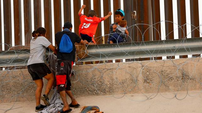 Migranten an der mexikanischen Grenze überwinden den Grenzzaun zu den USA