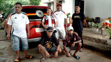 Familie in Indonesien mit Fan-Artikeln der deutschen Fußball-Nationalmannschaft.