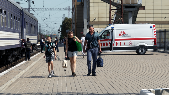 Sohn, Mutter und Vater am Bahnhof