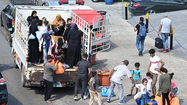 Menschen laden einen Lastkraftwagen ab.