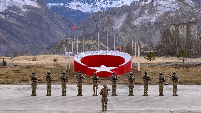 Soldaten vor dem türkischen Wappen in einer Berglandschaft