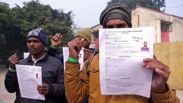 Indische Arbeiter zeigen Dokumente