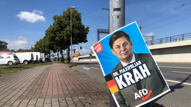 Ein Wahlplakat, auf dem der AfD-Politiker Maximilian Krah abgebildet ist, hängt an einem Laternenmast am Boden.