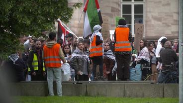 Studierende protestieren vor einer Hochschule.