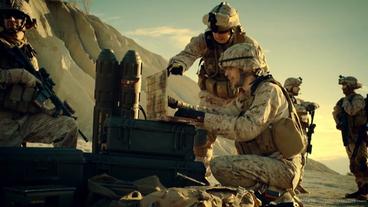 Moderne Kriegsführung im Imagefilm: Zwei Soldaten sitzen im Freien und beraten sich an einem Laptop.