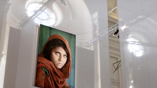"Afghan Girl" von 1984 ist eine der bekanntesten und eindrucksvollsten Arbeiten von Steve McCurry. Es zeigt die zehnjährige Sharbat Gula, die damals seit zwei Jahren in einem Flüchtlingscamp in Pakistan lebte. Die Doku beleuchtet Entstehung und Wirkung des Bildes.
