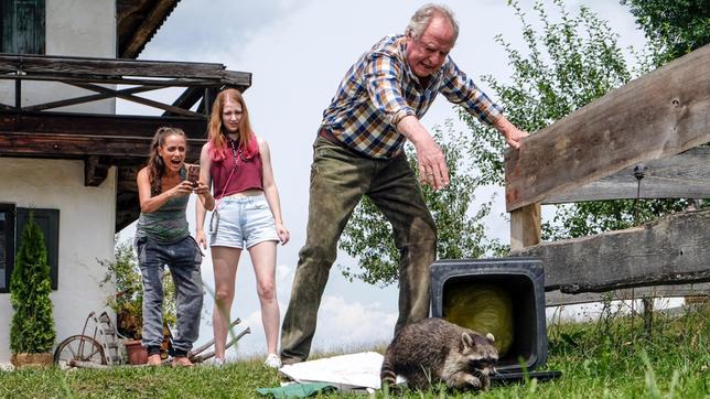 Barthl (Friedrich von Thun) jagt den tierischen Gast. Janine Brieschke (Anna Thalbach, li.) und ihre Tochter Tanja (Rebecca Kleineidam) filmen begeistert.