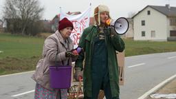 Oma Eberhofer und ihr Sohn auf der Straße mit einem Megafon. 