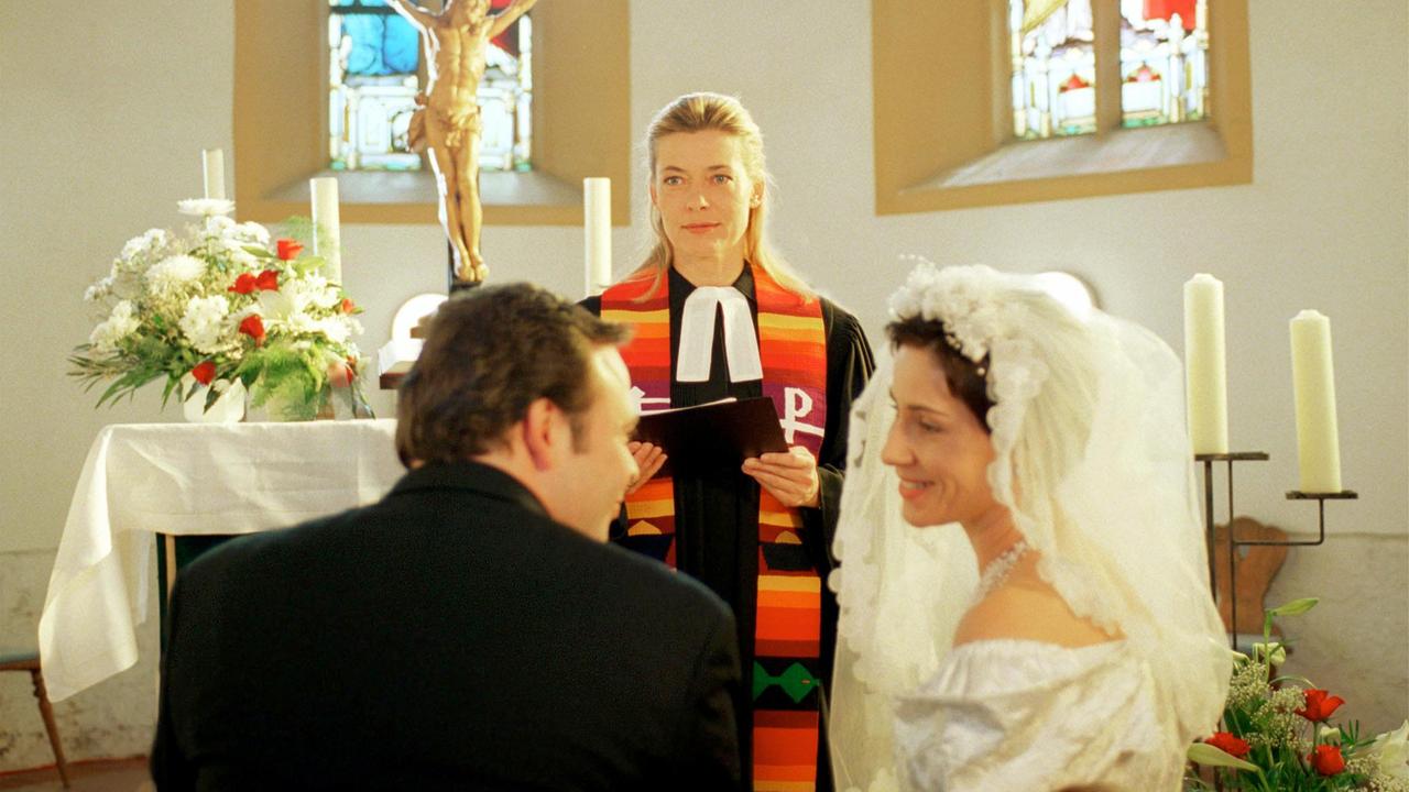 Die engagierte Dorfpfarrerin Anja Schneider ist in der ganzen Gemeinde überaus beliebt. Die verwitwete Pfarrerin Anja Schneider (Barbara Rudnik) traut ein glückliches Brautpaar.