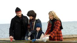 Ned (Liev Schreiber, li.), Jeannie (Helen Hunt, re.) und die Kinder Jonah (Ezra Miller) und Ethan (Skyler Fortgang) verstreuen Ernies Asche im Meer.