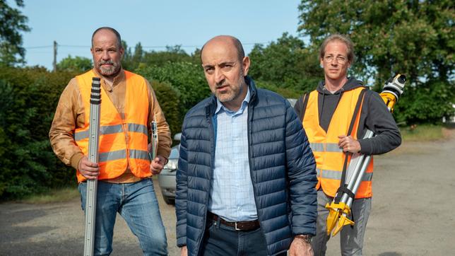 Heinrich Rückert (Yaşar Çetin, mi.) stößt mit seinem Bauvorhaben im Kleingartenverein auf heftigen Widerstand (mit Komparsen).