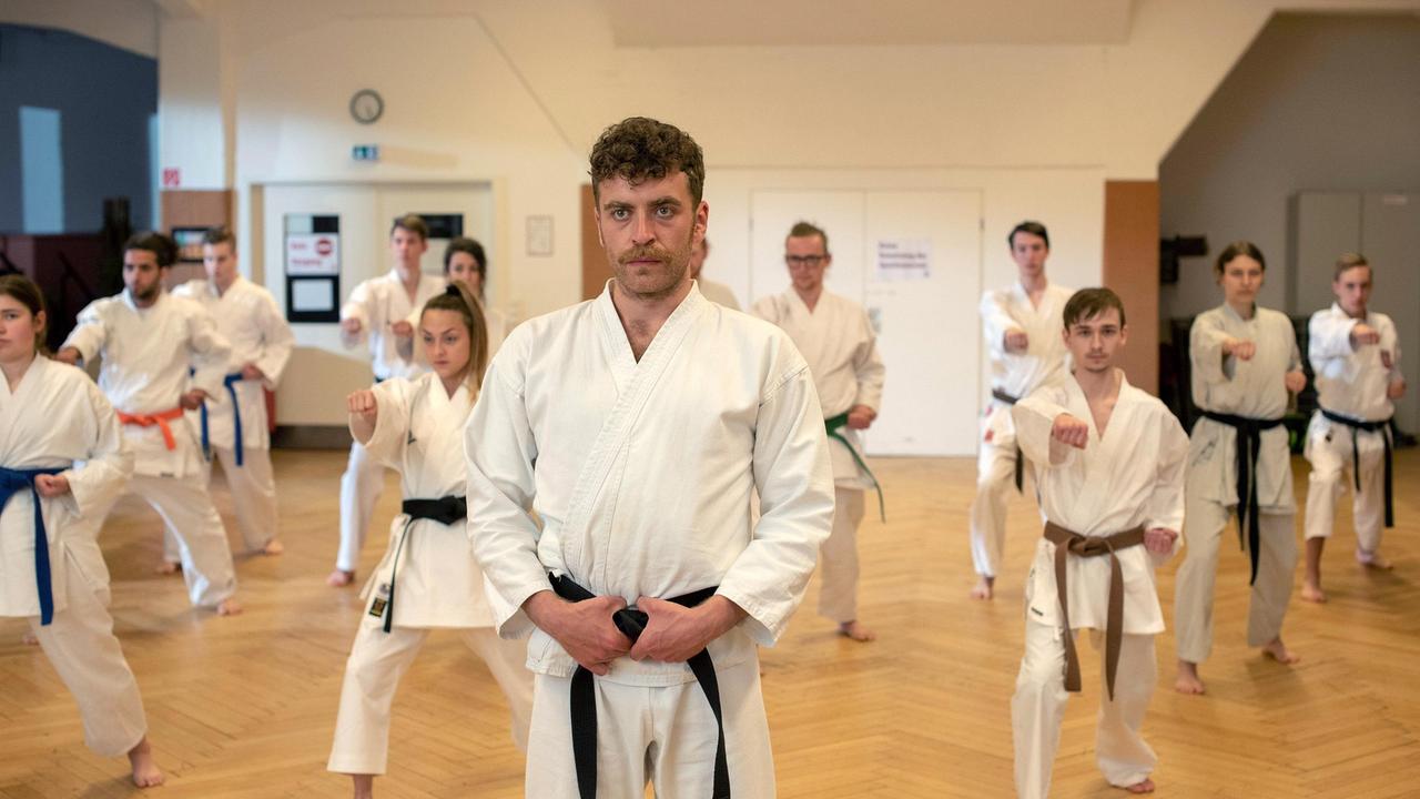 Nils Sanchez (Enrique Fiß) unterrichtet nebenbei Kinder und Jugendliche in Taekwondo (mit Niklas Post, 3.v.r. und KomparsInnen) .