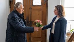 Girwidz (Michael Brandner) überrascht Monika Selitz (Marie Therese Futterknecht) mit einem Blumenstrauß.