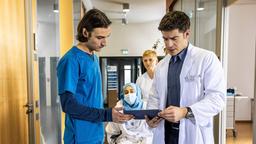 Assistenzarzt Ivo Maric (Jakob D'Aprile, li.) und Oberarzt Dr. Ben Ahlbeck (Philipp Danne, re.) entdecken eine postoperative Komplikation, die bei Filiz Basarni (Tua El-Fawwal, mi. mit Komparse) Schuldgefühle auslöst.