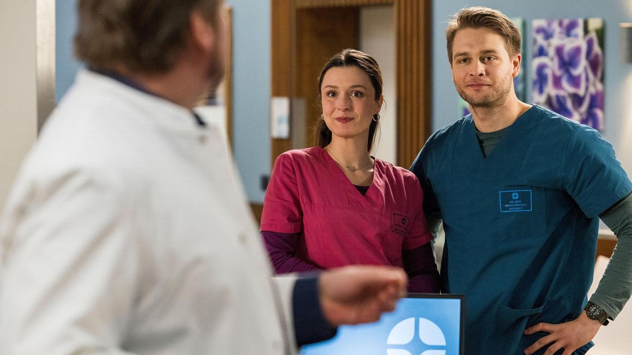 Viktoria Stadler (Isabella Krieger) teilt mit Vorfreude spannende Neuigkeiten mit Mikko (Luan Gummich) und Dr. Marc Lindner (Christian Beermann).