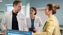 Dr. Maria Weber (Annett Renneberg, mi.) beobachtet, wie die Patientin Verena Kehrmeier (Elisabeth Baulitz, re.) mit Dr. Kai Hoffmann (Julian Weigend, li.) flirtet.