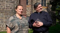 Frau Kübel (Svenja Hermuth) und Pastor Puttermann (Johannes Rotter) sehen Hindus bei deren Gottesdienst zu. Die Pastoralreferentin missbilligt diese Art von Gottesverehrung.