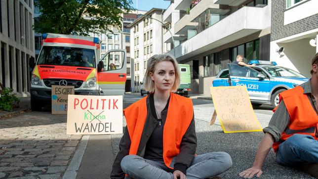 Anka Emem (Sarah Mahita) ist entsetzt darüber, wie aggressiv einige Leute auf ihren Klimaschutzprotest reagieren.