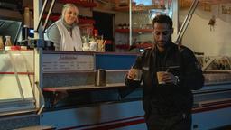 Während der Nachtschicht holt Polizist Brahmann (Karim Günes) Kaffe für sich und seinen Kollegen am Ibisswagen (mit Maraile Woehe).