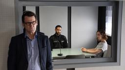 Während Ida Müller-Dogan (Amelie Plaas-Link) den Polizisten Brahmann (Karim Günes) vernimmt, hält Lars Englen (Ingo Naujoks) sich im Hintergrund.
