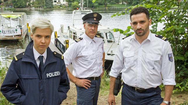 Skeptisch verfolgen Marlene Weber (Oska Melina Borcherding), Wolf Malletzke (Christoph Grunert) und Fahri Celik (Hassan Akkouch) die Aussagen der Umweltaktivist:Innen im Camp an der Havel.