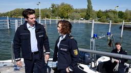 Jakob Frings (Max König) und Julia Demmler (Wendy Güntensperger) haben auf dem See eine herrenlose Segeljolle entdeckt. Vom Segler fehlt jede Spur.