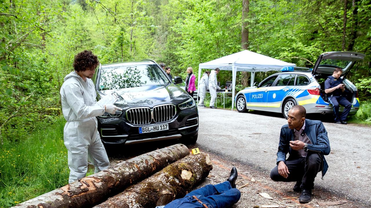 Ein Tatort am Holzlagerplatz: Der Tote ist Kabarettist Kuno Horn. Dr. Philipp Hartmann (Jakob Graf) klärt Jerry (Peter Marton) über die Umstände auf. Genauere Informationen verspricht er sich jedoch erst nach der Obduktion (mit Komparserie).