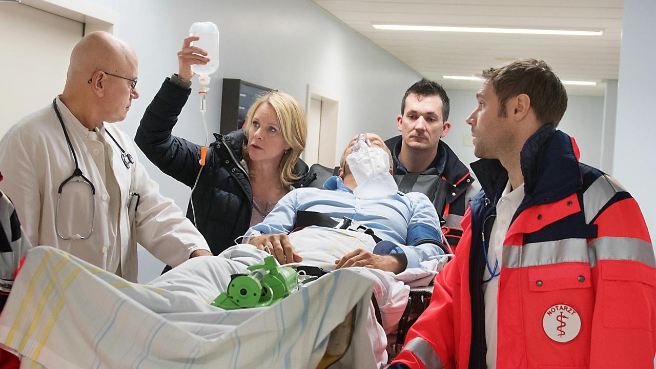 Arthur (Jochen Horst) wird nach einer Schussverletzung ins Krankenhaus eingeliefert. Nora (Anne Moll, 2.v.l. mit Komparsen) bangt um sein Leben!