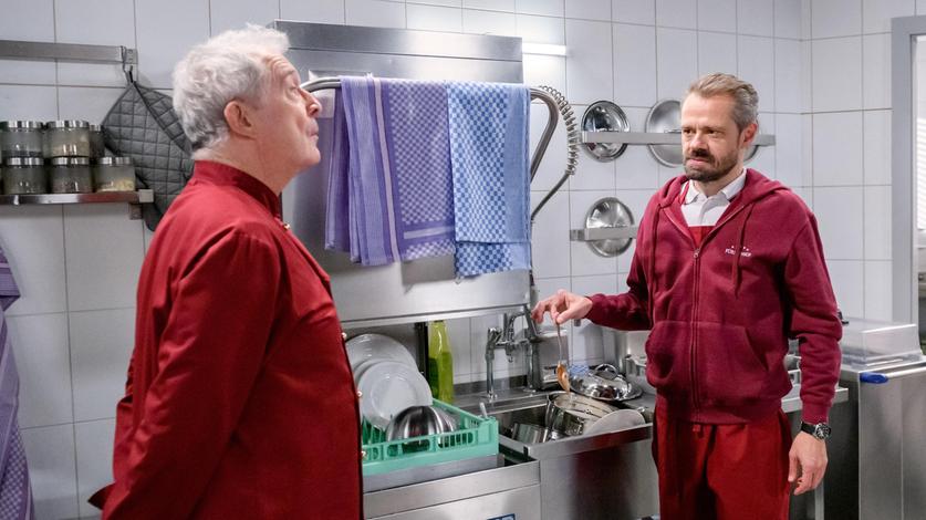 Erik (Sven Waasner) tut sich schwer damit, dass Werner ihn zu Hilfsarbeiten in Andrés (Joachim Lätsch) Küche verdonnert hat.